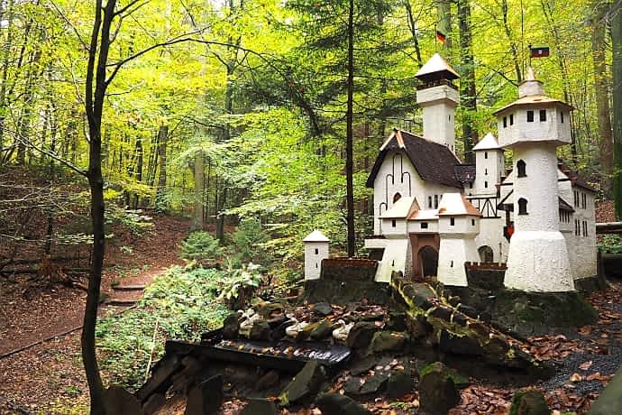 [title] - Kleine Burgen, Mühlen und Märchenfiguren mitten im Wald: Der Märchenpfad durch die Obrunnschlucht ist ein ungewöhnliches Ausflugsziel im Odenwald und besonders mit Kindern schön. Der Weg folgt dem Obrunnbach vorbei an zahlreichen liebevoll gestalteten Miniaturwelten.