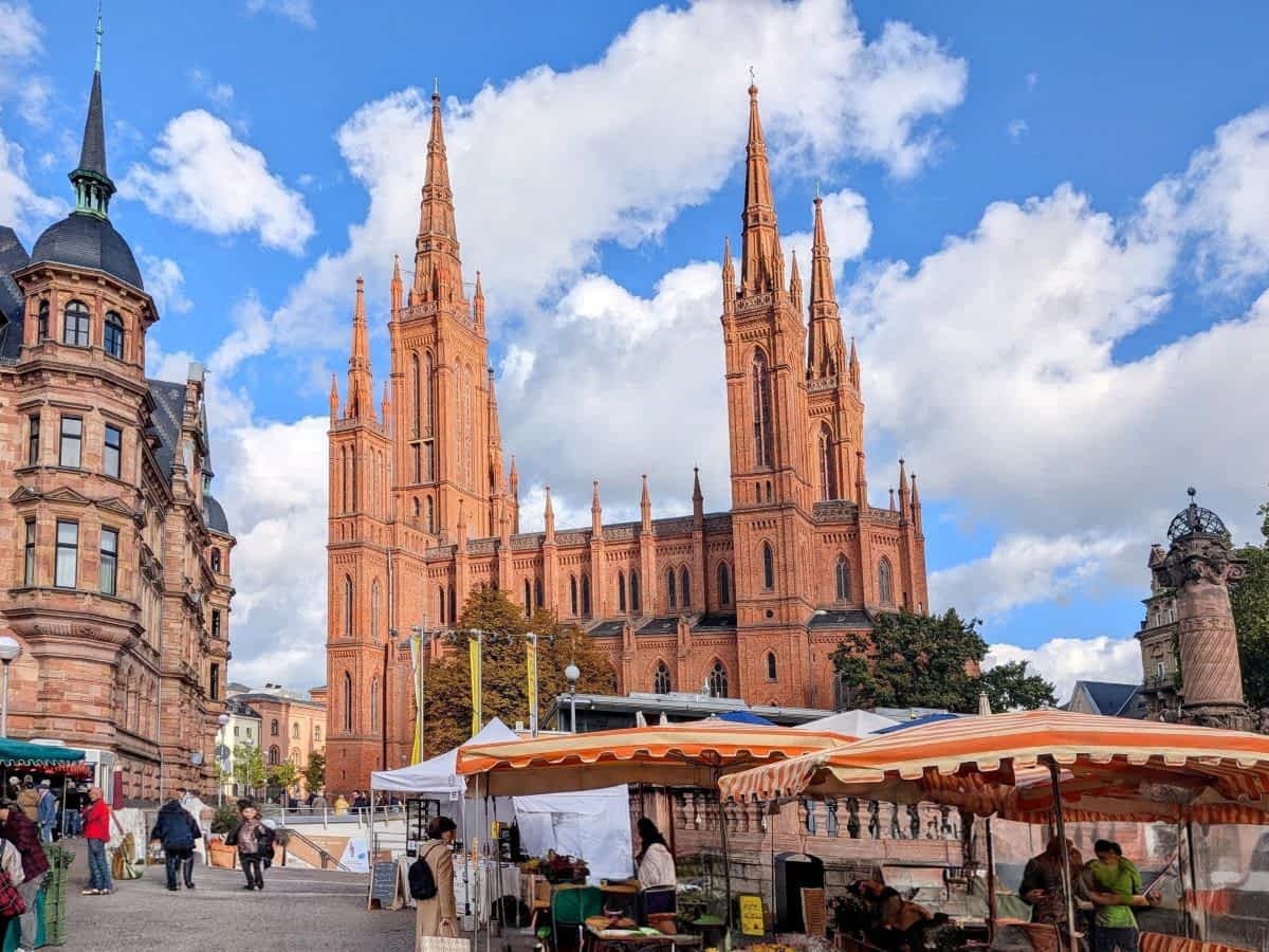 Wochenmarkt auf dem Schlossplatz in Wiesbaden mit Marktständen und der im Hintergrund aufragenden neugotischen Marktkirche