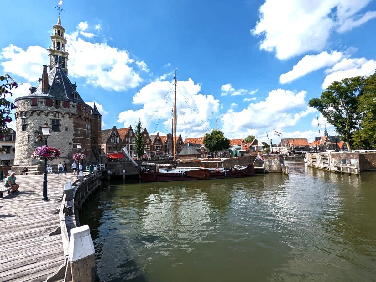 Blick auf den Hafen von Hoorn mit dem historischen Hoofdtoren, einem alten Segelschiff am Kai und typisch niederländischen Giebelhäusern im Hintergrund. Blick auf den Hafen von Hoorn mit dem historischen Hoofdtoren, einem alten Segelschiff am Kai und typisch niederländischen Giebelhäusern im Hintergrund.