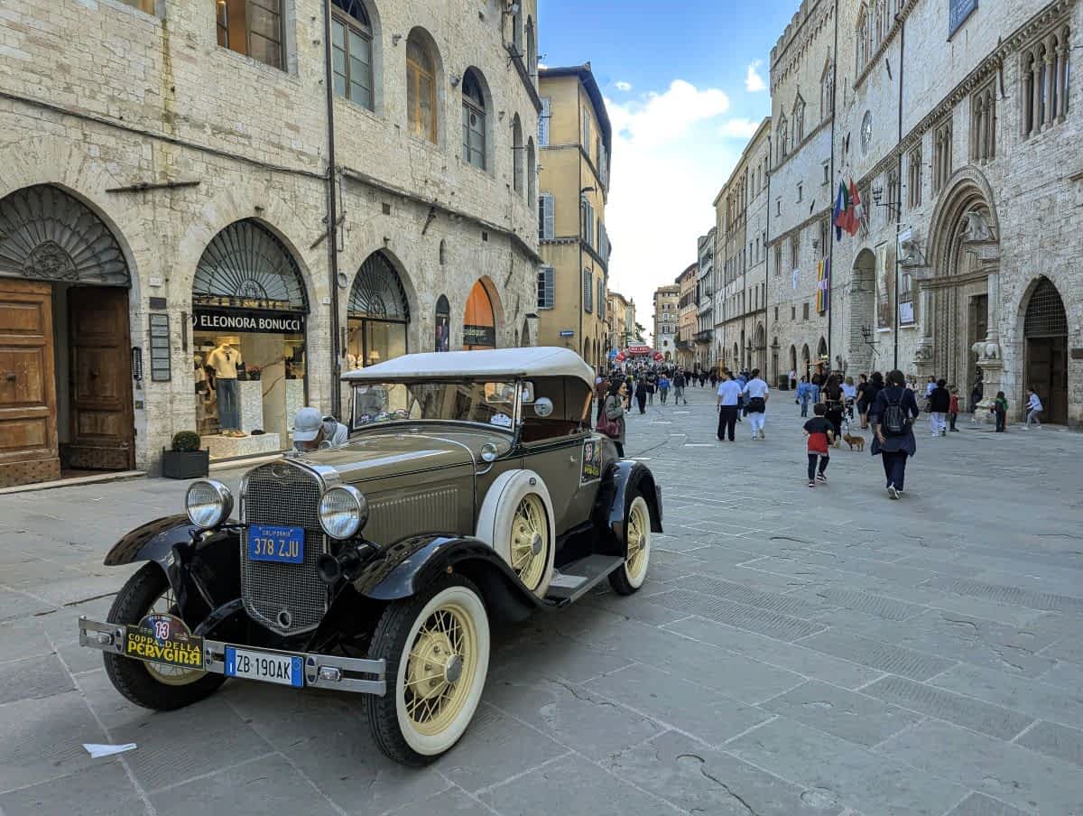 Historisches Auto in Perugias Altstadt, umgeben von alten Gebäuden.