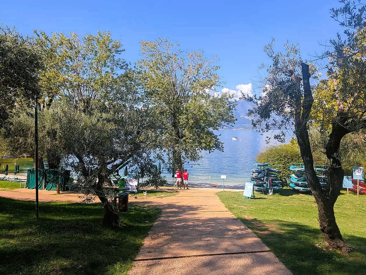 Baia delle Sirene bei Punta San Vigilio am Gardasee mit Olivenbäumen und Badebucht