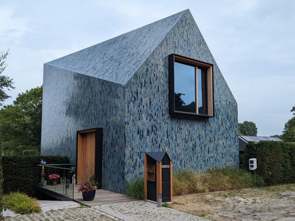 Malerisches, hellblau gestrichenes Holzhaus direkt an einem ruhigen Kanal