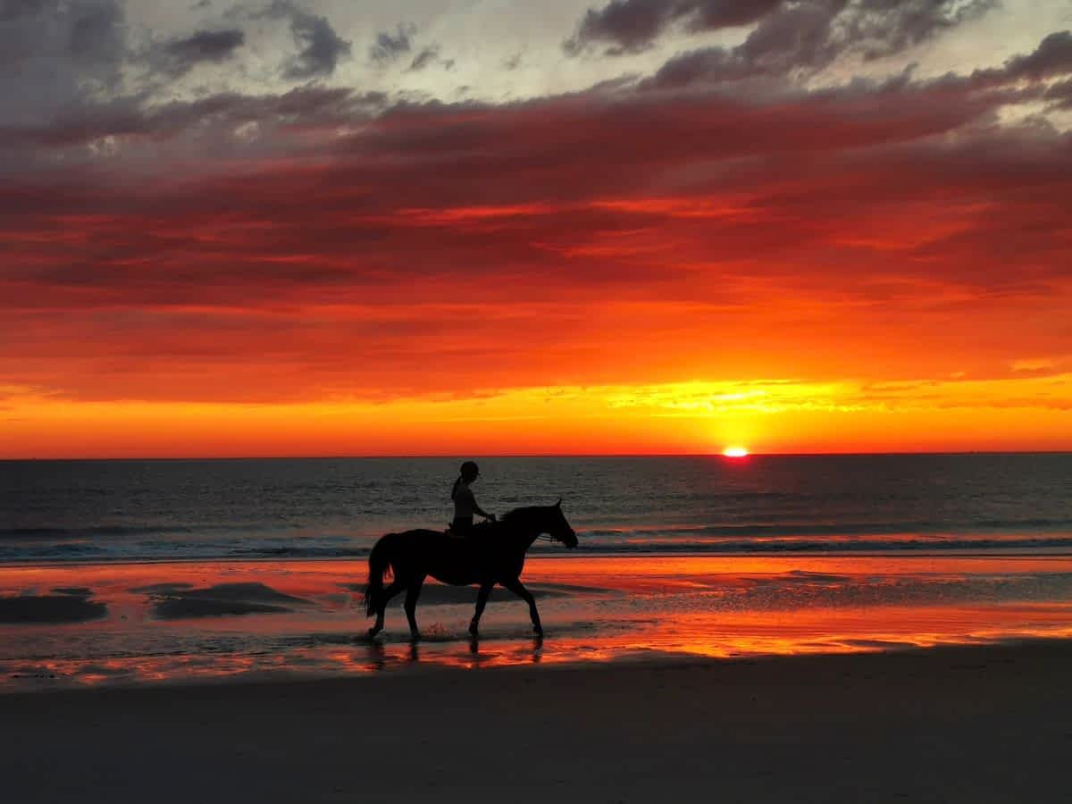Reiten am Strand im Sonnenuntergang