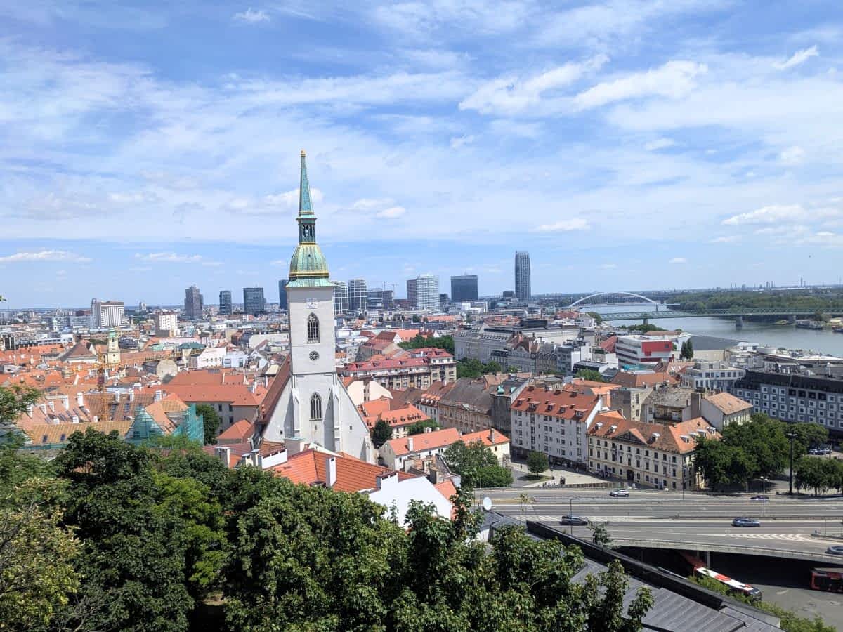 Bratislava: Blick von der Burg über die Altstadt: Der Martinsdom ragt aus dem Meer von roten Dächern hervor, dahinter fließt die Donau.